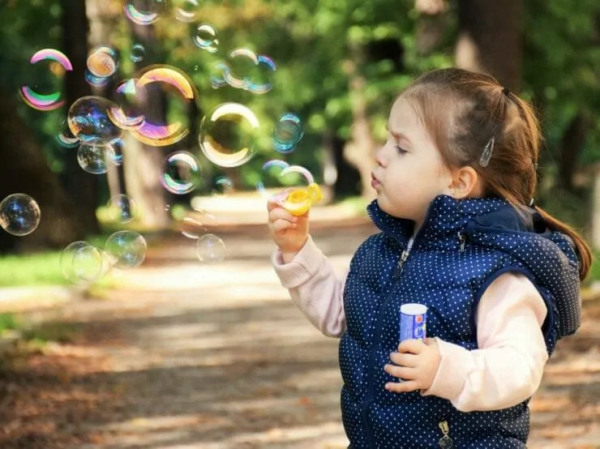 Little girl blowing bubbles.